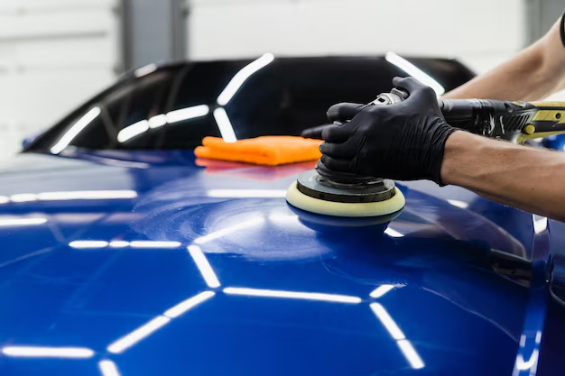 Machine polishing the hood of a blue car